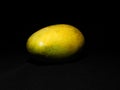A very unique picture of a ripen mango under dark background