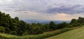 Very wide panoramic view of the Blue Ridge Mountains of North Carolina on a hazy, overcast day, dark tree line, bushes, and lush g Royalty Free Stock Photo