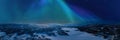 Very wide scenic aerial panorama on frozen lake, mountains with snow mobile traces, northern green lights over mountains Royalty Free Stock Photo