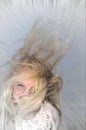 Very wind-swept girl on blue/grey. Royalty Free Stock Photo