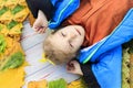 Very yellow. funny girl lying on a fallen leaf. blue jacket. eye squeezed. close-up