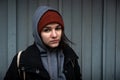 Very young hungry and scared homeless teenager girl standing alone on the street in the cold winter day feeling abandoned and anxi