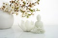 Vesak, Wesak, Buddha birthday. Buddha statue with blossoming cherry on white background. Spa ritual. Mental health and