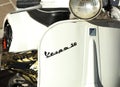 Vespa 50 logo on the white front faitring of the scooter.