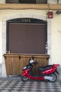 Vespa moped near old closed cafe