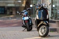 Vespa scooter and motorcycle parked on the pavement of the old town