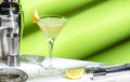 Vesper cocktail drink with dry gin, vodka, aperitif, lemon zest and ice in martini glass. Light green background, hard light, Royalty Free Stock Photo