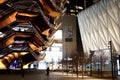 Vessel TKA, a spiral endless staircase with the Shed near it, skyscrappers behind. Night view with bright lights. Hudson Yards