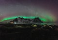 Vestrahorn Stockknes mountain range with aurora borealis and reflection at the beach in Iceland. One of the most