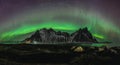 Vestrahorn Stockknes mountain range with aurora borealis and reflection at the beach in Iceland. One of the most