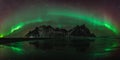 Vestrahorn Stockknes mountain range with aurora borealis and reflection at the beach in Iceland. One of the most