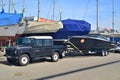 Old classic veteran 4 offroad car Landrover pickup version with motorboat on a trailer