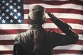 Veterans Day, Memorial Day, Independence Day. A female soldier saluting, against the background of the American flag. Rear view Royalty Free Stock Photo