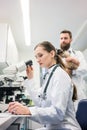 Veterinarian doctors analyzing blood samples of cat in microscope