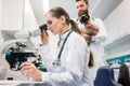 Veterinarian doctors analyzing blood samples of cat under microscope