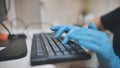 The veterinarian is typing on the keyboard in blue gloves. Royalty Free Stock Photo