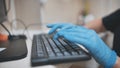 The veterinarian is typing on the keyboard in blue gloves. Royalty Free Stock Photo