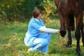 Veterinarian in uniform examining beautiful brown horse outdoors. Royalty Free Stock Photo