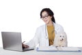 Veterinarian uses laptop with puppy on desk