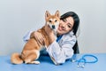 Veterinarian woman wearing uniform at the clinic, hugging dog with love Royalty Free Stock Photo