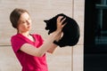 Veterinarian is a young girl in a medical gown holding a black cat in her arms Royalty Free Stock Photo