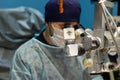 A veterinary surgeon performs surgery on a pet's eyes in a veterinary clinic. An ophthalmologist performs
