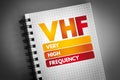 VHF - Very High Frequency acronym on notepad, technology concept background