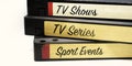 VHS tapes stacked and with labels indicating the various genres of television entertainment recorded on the tape. Television video Royalty Free Stock Photo