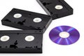 VHS video tapes and DVD disk in middle  on white Royalty Free Stock Photo