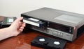 VHS videocassette is put into the video recorder to watch the video, another video cassette is on the video-tape recorder Royalty Free Stock Photo