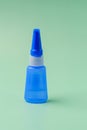 Vial with blue plastic glue on a green background