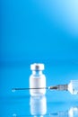 Vial with Covid-19 vaccine and a syringe with a drop of vaccine on the needle Royalty Free Stock Photo