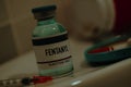 vial of fentanyl and syringe in a sordid bathroom