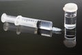 Vial and hyperdermic needle with vaccine on a black background. Worldwide covid 19 pandemic Royalty Free Stock Photo