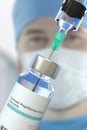 Vial with human papilloma virus HPV vaccine and needle of a syringe against blurred doctor`s face. 3D rendering Royalty Free Stock Photo