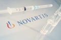 Vials of liquid on a white table and the logo of a large pharmaceutical company Novartis Royalty Free Stock Photo