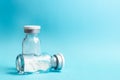 Vials of medicine in powder form on blue background, soft focus