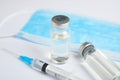 Vials, syringe and surgical mask on background. Vaccination and immunization