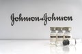 Vials vaccine and syringe on blurry Johnson & Johnson background