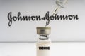 Vials vaccine and syringe on blurry Johnson & Johnson background