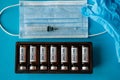 Vials with vaccine, syringe, gloves and face mask on blue background, close up. Vaccination coronavirus covid-19 and immunity Royalty Free Stock Photo