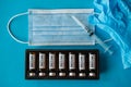 Vials with vaccine, syringe, gloves and face mask on blue background, close up. Vaccination coronavirus covid-19 and immunity Royalty Free Stock Photo