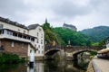 Vianden, Luxembourg - July 27, 2019: Vianden Castle on a hill with a bridge, a restaurant and Our river in Vianden, Luxembourg Royalty Free Stock Photo
