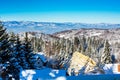 Vibrant aerial winter mountain panorama, snow trees, blue sky