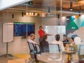 In the vibrant ambiance of a modern startup office, a diverse group of businesspeople gathers around a meeting table