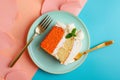 Delicious slice of carrot cake with cream topping on a blue plate Royalty Free Stock Photo