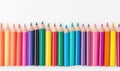 A vibrant array of colored pencils arranged neatly on a clean, white surface creating a colorful border against the background Royalty Free Stock Photo