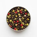 A vibrant assortment of colorful peppercorns displayed in a round metal container for culinary use Royalty Free Stock Photo