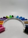 Colorful Sewing Thread Spools Arranged in a Rainbow Arc on White Background Royalty Free Stock Photo