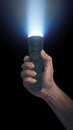 Glowing contrast Black flashlight in hands casts a radiant white beam